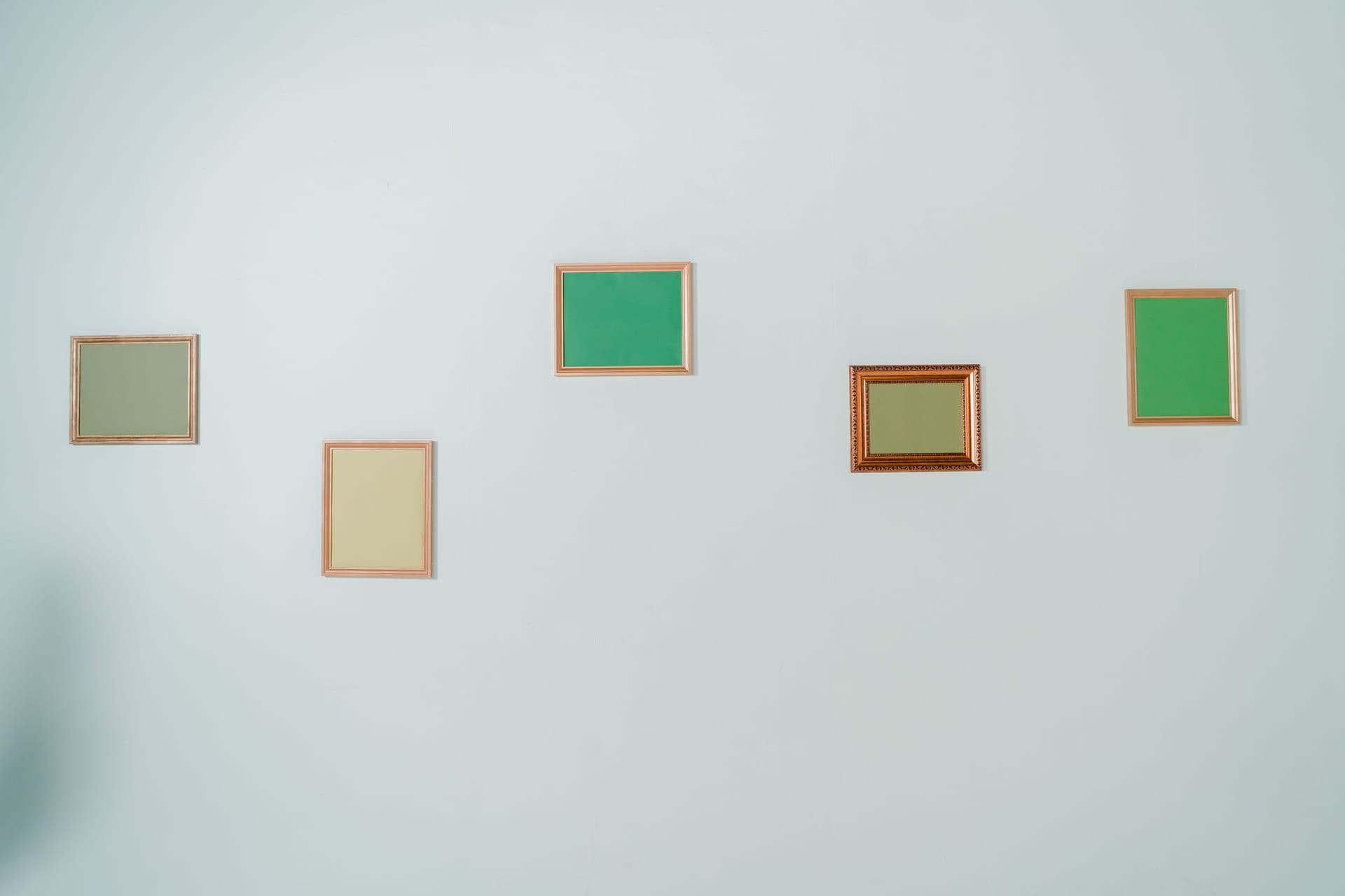 Evenly spaced framed prints on a wall above a sideboard