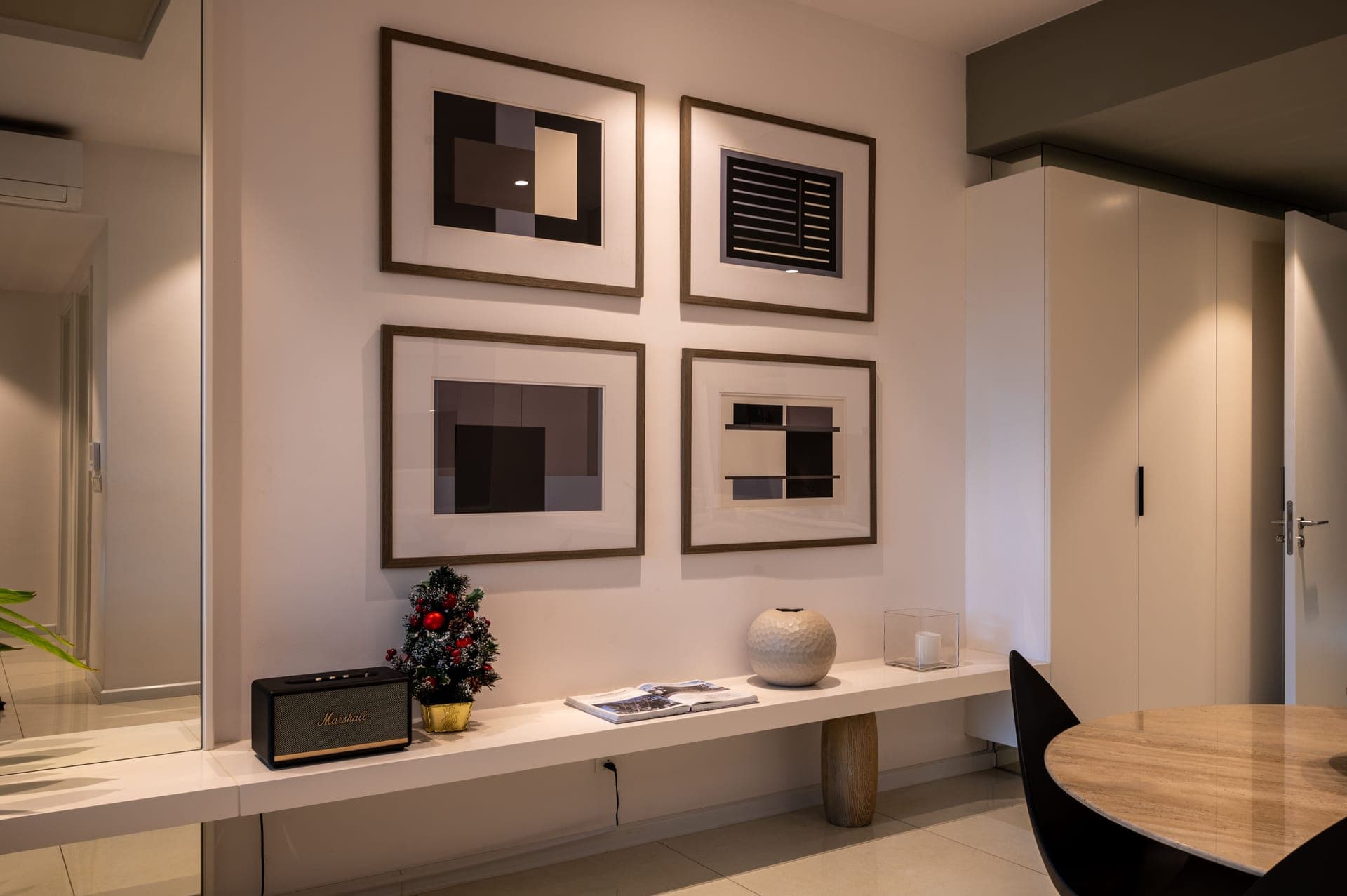 A living room wall with framed prints above a low sofa